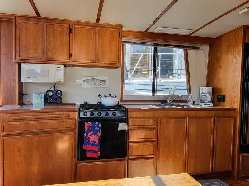 Slide: The Image of Cozy kitchen interior of a 1992 Corsair 42 boat with wooden cabinets and appliances. - 15