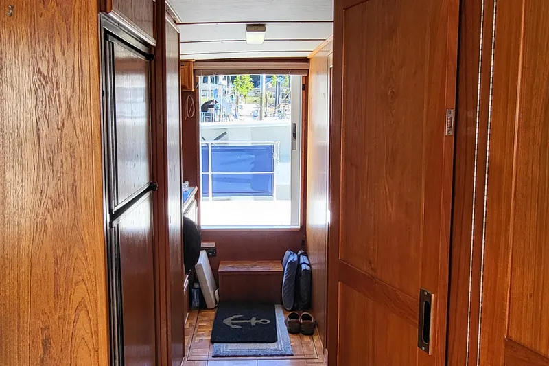 Slide: The Image of Interior hallway of a 1992 Corsair 42 boat with wooden paneling and nautical decor. - 19