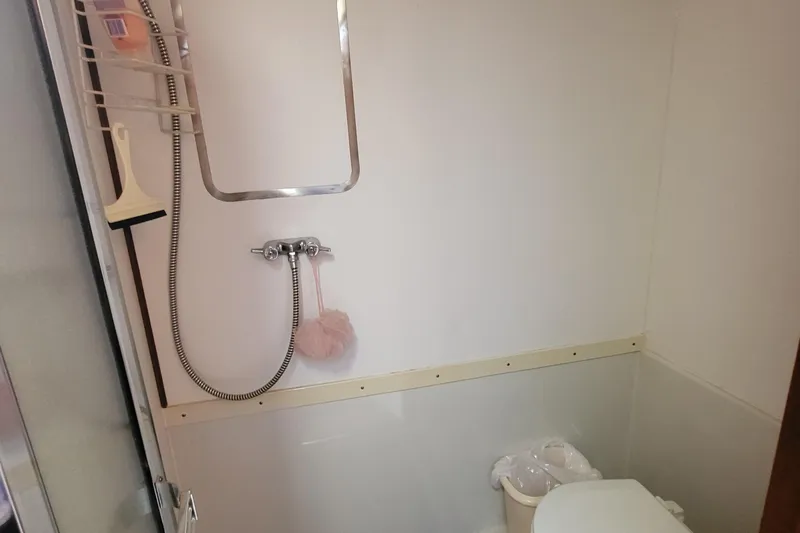 Slide: The Image of Bathroom interior of a 1992 Corsair 42, featuring a shower and toilet. - 28
