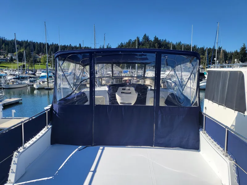Slide: The Image of 1992 Corsair 42 boat docked at a marina, featuring a blue canopy and clear windows. - 3