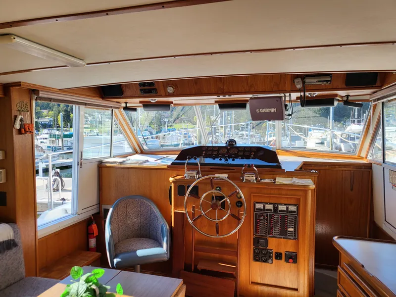 Slide: The Image of Interior of a 1992 Corsair 42 boat with wooden helm and marina view. - 7