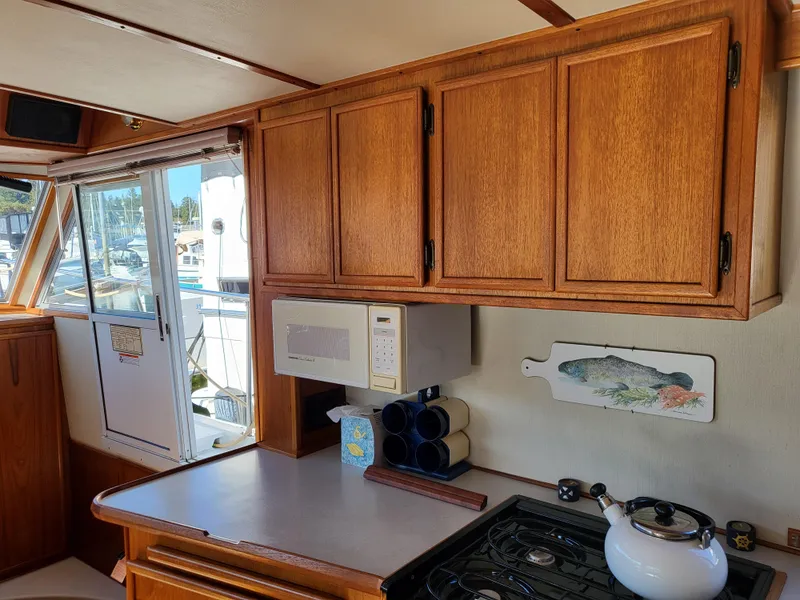 Slide: The Image of Interior of a 1992 Corsair 42 boat with wooden helm and marina view. - 12