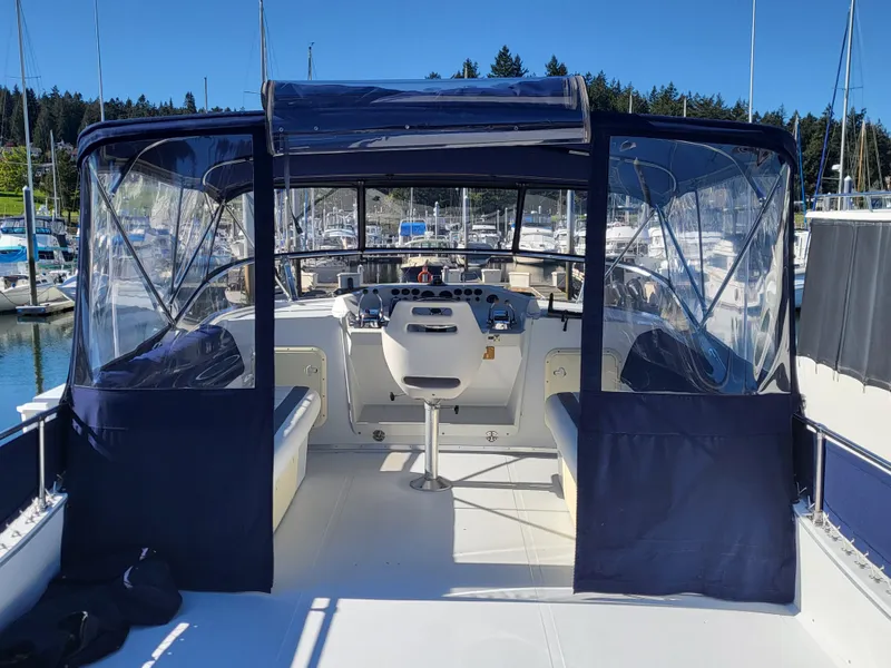 Slide: The Image of 1992 Corsair 4200 boat cruising on a serene lake with lush forest backdrop. - 4