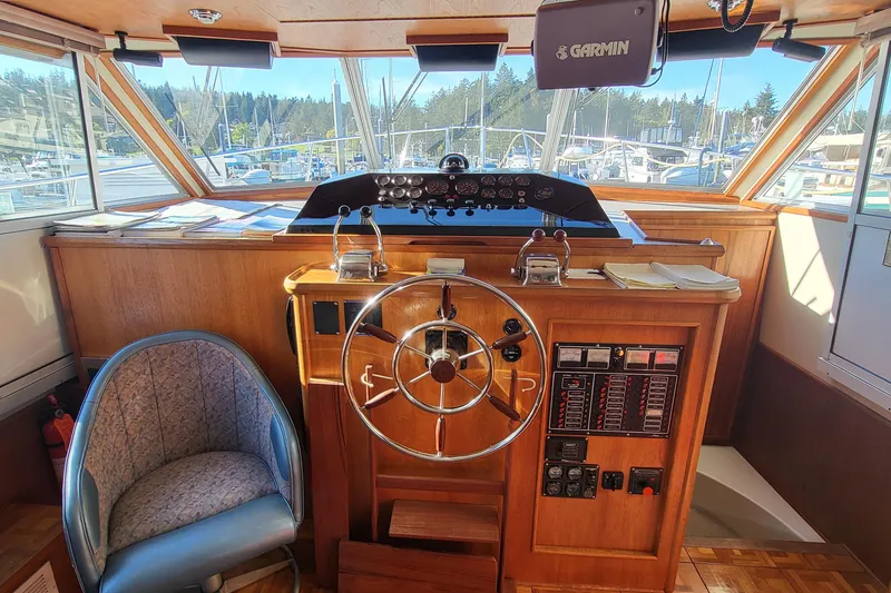 Slide: The Image of 1992 Corsair 42 boat docked at a marina, featuring a blue canopy and clear windows. - 8