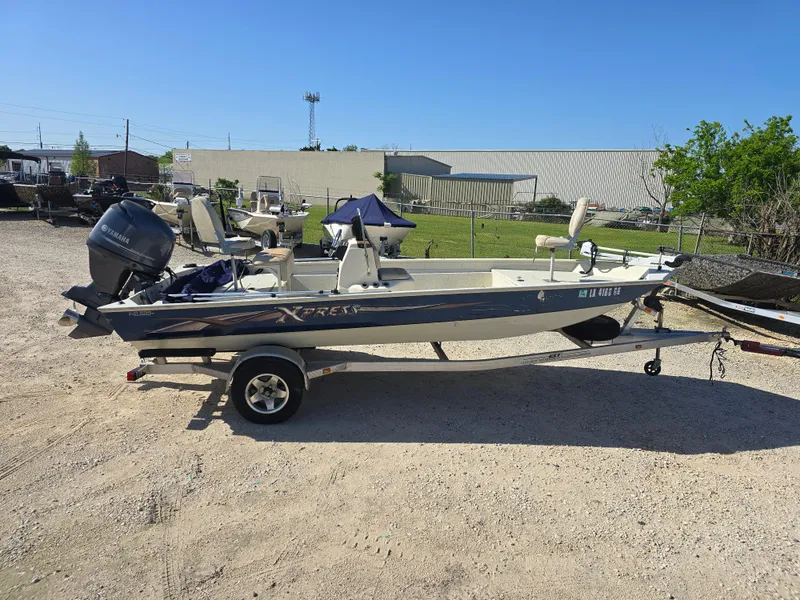 Slide: The Image of 2013 Xpress H20B boat on trailer, parked outdoors under clear blue sky. - 3