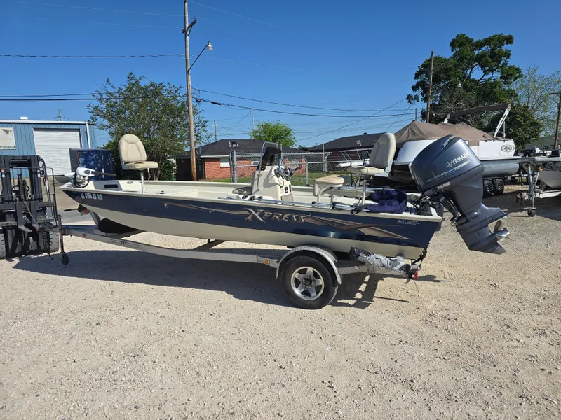 Slide: The Image of 2013 Xpress H20B boat with Yamaha outboard motor on a trailer, parked outdoors. - 6