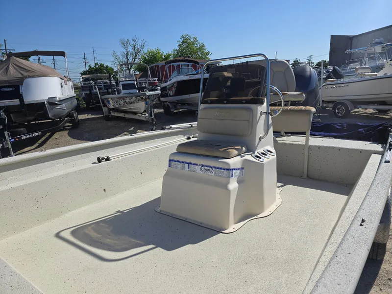Slide: The Image of 2013 Xpress H20B boat with center console, parked in a marina under clear skies. - 8