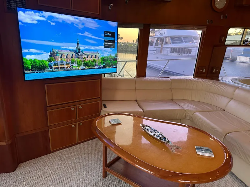 Slide: The Image of Luxurious yacht interior with leather seating, wooden table, and large TV displaying scenic view. - 10