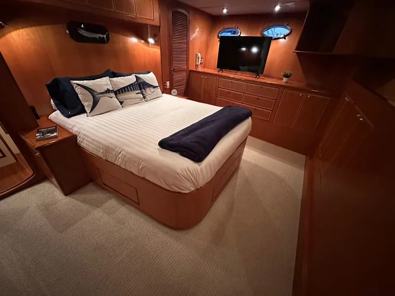 Slide: The Image of Luxurious bedroom interior of 1999 Mikelson Long-Range Luxury Sportfish yacht with elegant wood finishes. - 20