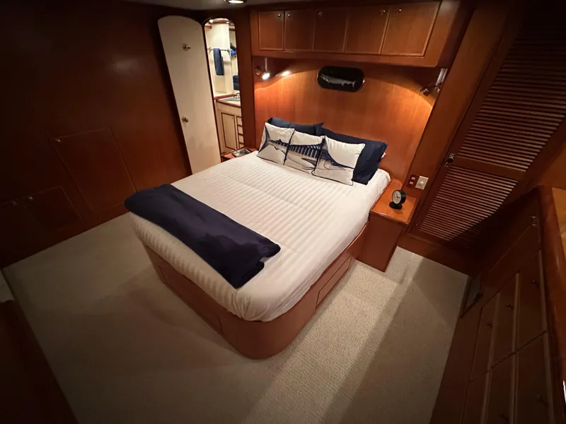 Slide: The Image of Luxurious bedroom in 1999 Mikelson Long-Range Luxury Sportfish yacht, featuring elegant wood finishes. - 21