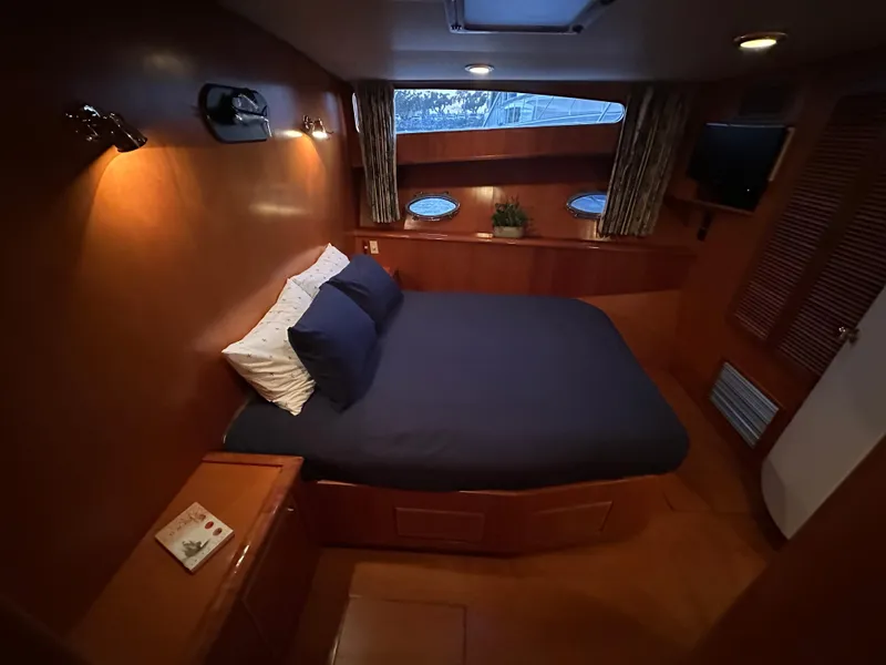 Slide: The Image of Luxurious cabin interior of a 1999 Mikelson Long-Range Luxury Sportfish yacht with cozy bedding. - 28