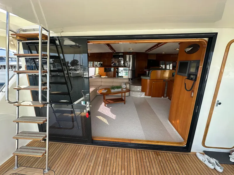 Slide: The Image of Interior view of a 1999 Mikelson Long-Range Luxury Sportfish yacht, featuring elegant wood finishes. - 49