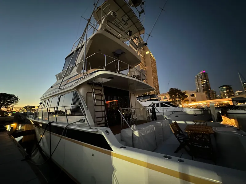 Slide: The Image of 1999 Mikelson Long-Range Luxury Sportfish yacht docked at sunset in a city marina. - 6