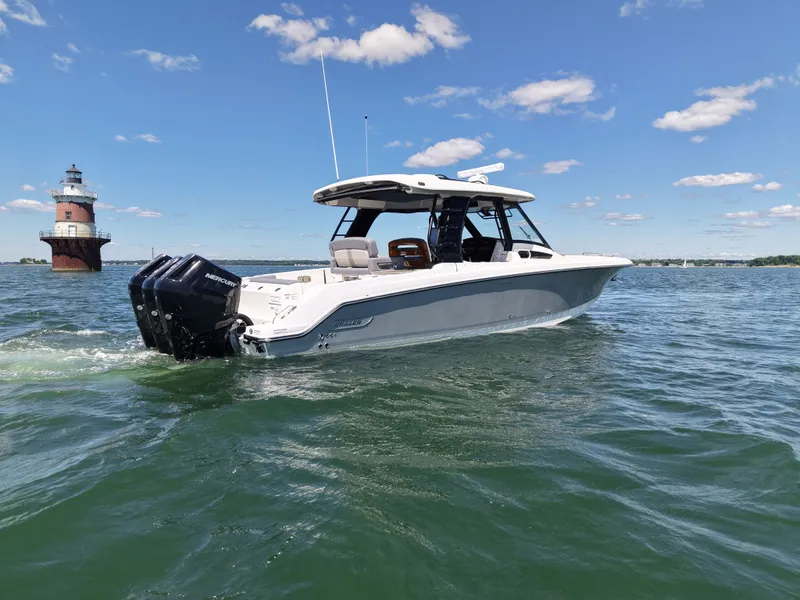 Slide: The Image of Boston Whaler 350 Realm 2026 on water near a lighthouse. - 1