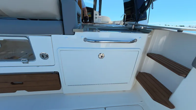 Slide: The Image of Boston Whaler 350 Realm 2026, interior view with seating and steps. - 22