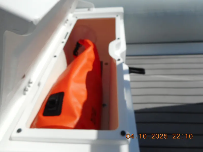 Slide: The Image of Open storage compartment in 2025 Highfield Classic 400 boat with orange bag inside. - 11