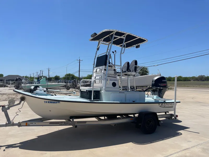 Slide: The Image of 2006 Explorer 19 boat on trailer with Yamaha outboard motor, parked outdoors. - 1