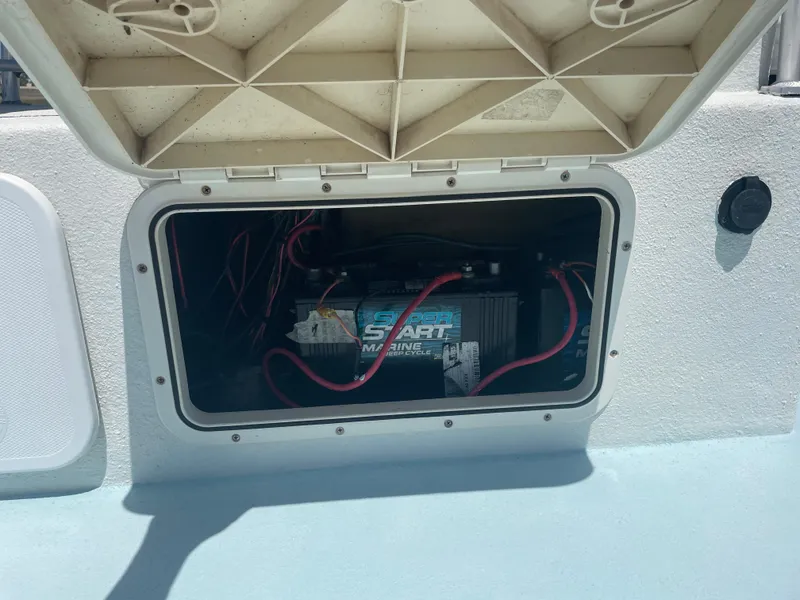 Slide: The Image of Boat battery compartment of a 2006 Explorer 19, featuring a Super Start marine battery. - 16