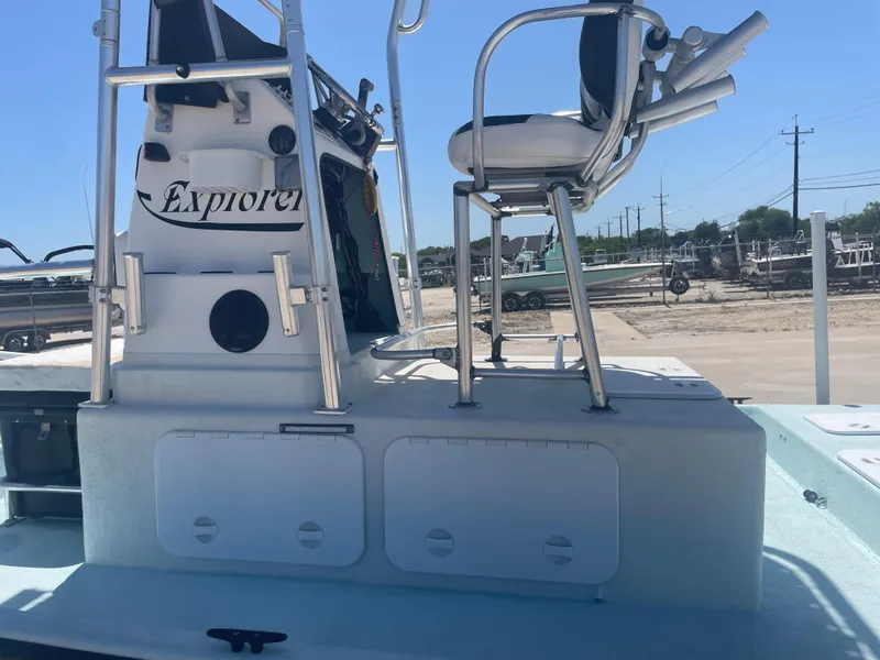 Slide: The Image of 2006 Explorer 19 boat with elevated seating and control panel, parked outdoors. - 19