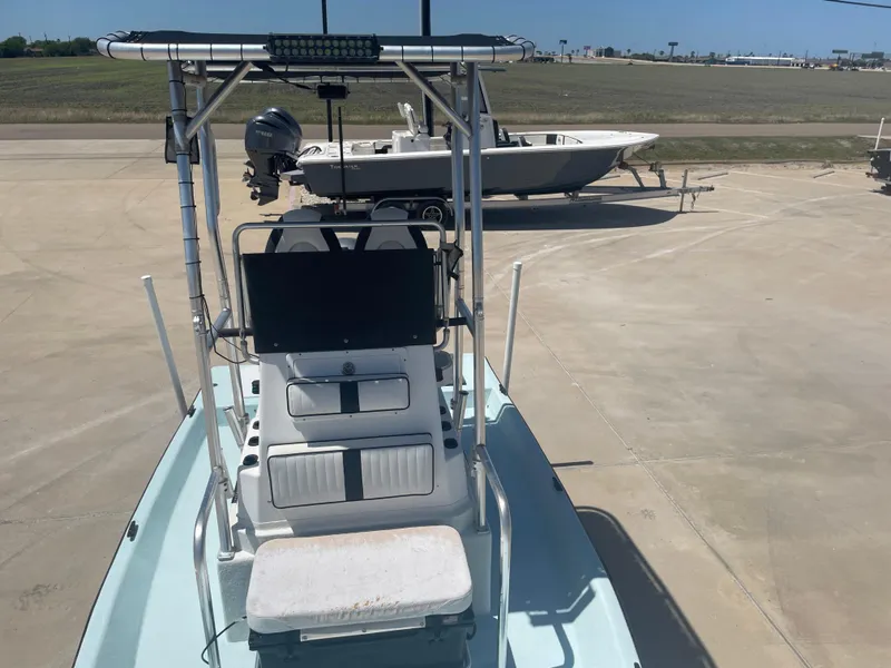 Slide: The Image of 2006 Explorer 19 boat with console and seating, parked on concrete surface. - 23