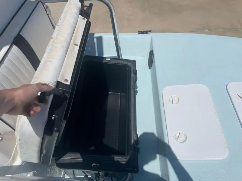 Slide: The Image of Open storage compartment on 2006 Explorer 19 boat deck, with hand holding lid. - 26