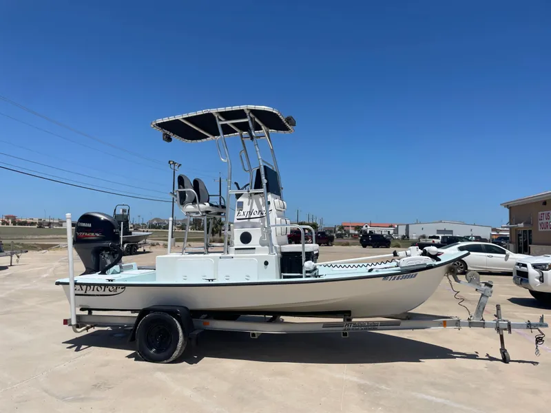 Slide: The Image of 2006 Explorer 19 boat on trailer with Yamaha outboard motor, parked outdoors. - 5