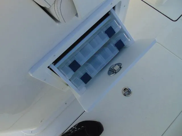 Slide: The Image of 2025 Parker 2600 CC boat with open storage compartment and tackle boxes. - 11