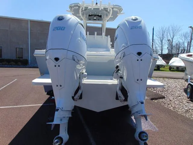 Slide: The Image of 2025 Parker 2600 CC boat with dual Yamaha outboard engines in a parking lot. - 2