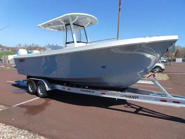 Slide: The Image of 2025 Parker 2600 CC boat on trailer, parked outdoors under clear blue sky. - 5