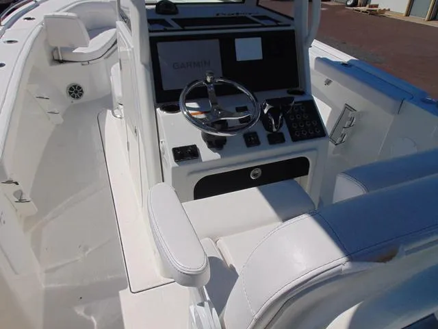 Slide: The Image of 2025 Parker 2600 CC boat cockpit with Garmin navigation system and sleek white seating. - 8