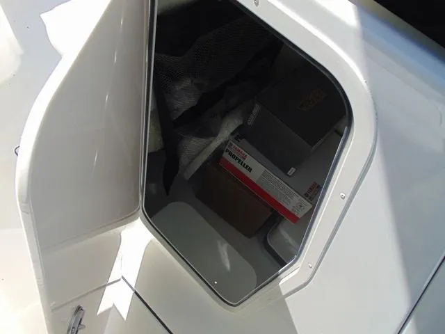 Slide: The Image of Storage compartment on a 2025 Parker 2200 CC boat, containing various items. - 16