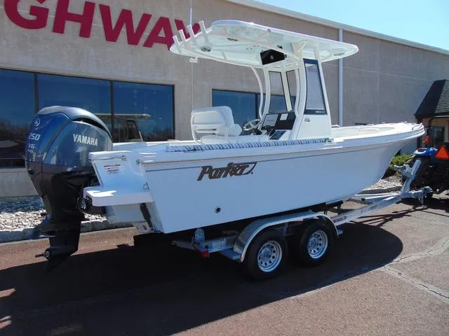Slide: The Image of 2025 Parker 2200 CC boat on trailer with Yamaha engine, parked outside a building. - 3