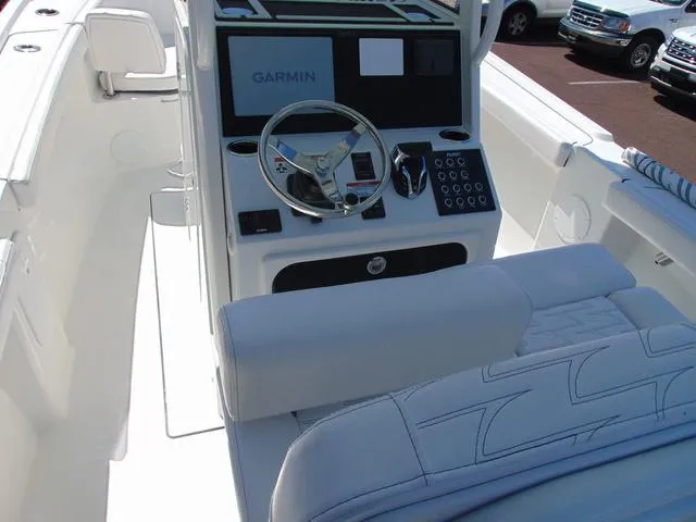 Slide: The Image of 2025 Parker 2200 CC boat cockpit with Garmin navigation system and white seating. - 6