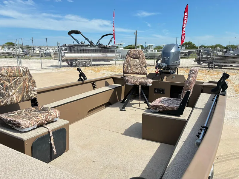 Slide: The Image of 2019 Smoker Craft 1660 SPORTSMAN boat with camo seats and Yamaha motor in a marina. - 12