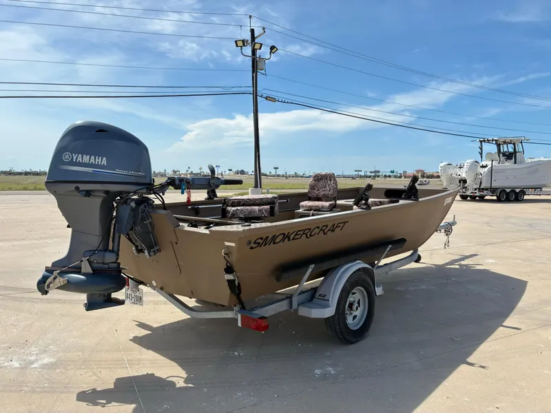 Slide: The Image of 2019 Smoker Craft 1660 Sportsman boat with Yamaha motor on trailer, parked outdoors. - 7