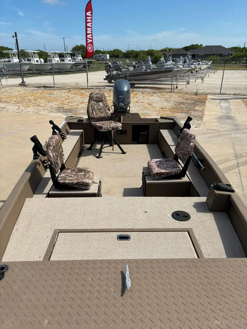 Slide: The Image of 2019 Smoker Craft 1660 SPORTSMAN boat with camo seats and Yamaha motor, parked outdoors. - 9