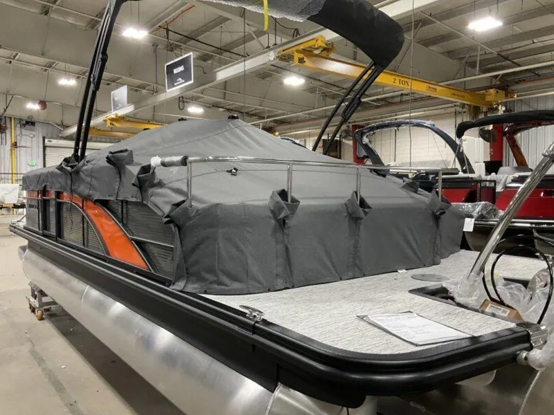 Slide: The Image of 2025 Bennington SX Swingback 22 SXSB pontoon boat with cover in a showroom. - 12