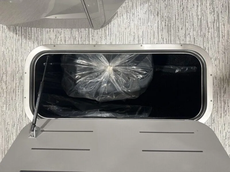 Slide: The Image of Storage compartment of 2025 Bennington SX Swingback 22 SXSB boat, with plastic-wrapped item inside. - 20