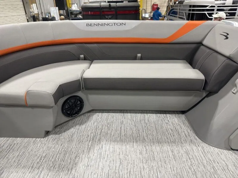 Slide: The Image of 2025 Bennington SX Swingback 22 SXSB boat interior with gray and orange seating. - 23