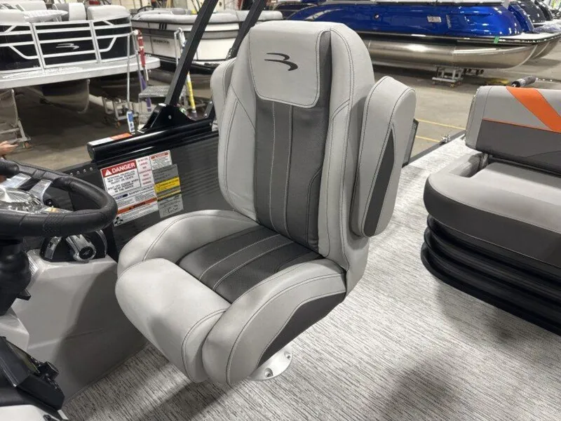 Slide: The Image of 2025 Bennington SX Swingback 22 SXSB captain's chair, gray and black upholstery, in a boat interior. - 25
