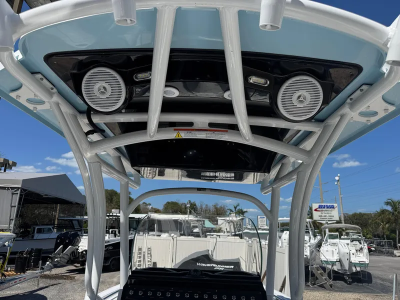 Slide: The Image of 2025 Wellcraft 222 Fisherman boat with speakers and canopy, displayed outdoors. - 10