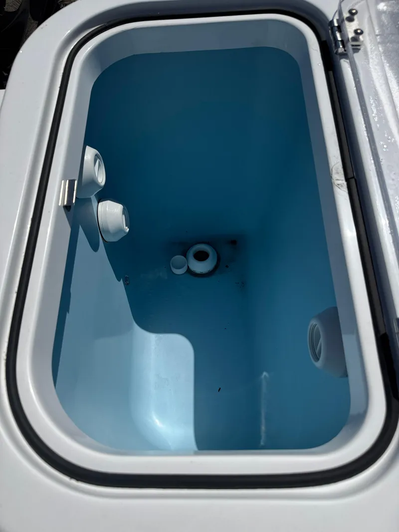 Slide: The Image of Livewell compartment in 2025 Wellcraft 222 Fisherman boat, featuring a sleek blue interior. - 14