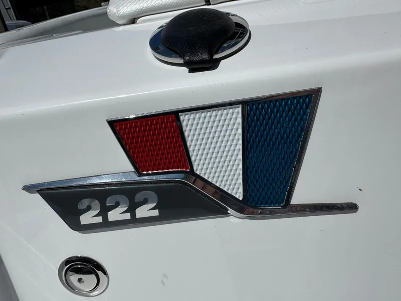 Slide: The Image of 2025 Wellcraft 222 Fisherman boat emblem with red, white, and blue design. - 6
