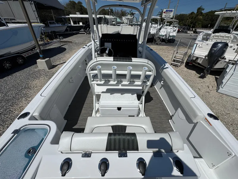Slide: The Image of 2025 Wellcraft 222 Fisherman boat interior with rod holders and seating, displayed outdoors. - 7