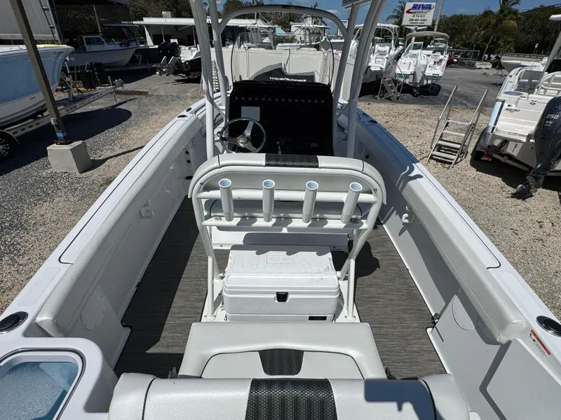 Slide: The Image of 2025 Wellcraft 222 Fisherman boat interior with seating and rod holders, docked at a marina. - 8