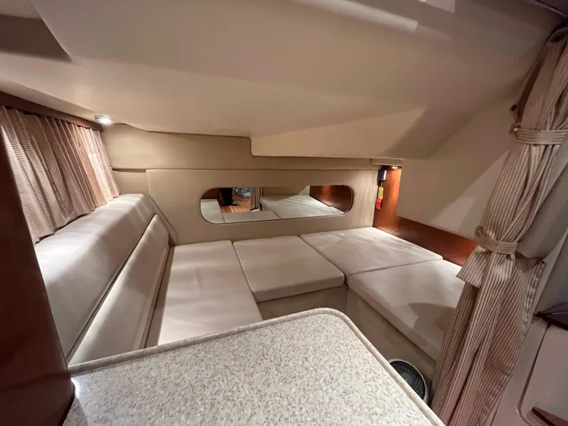 Slide: The Image of 2006 Regal 3360 Window Express cabin interior with beige seating and curtains. - 10