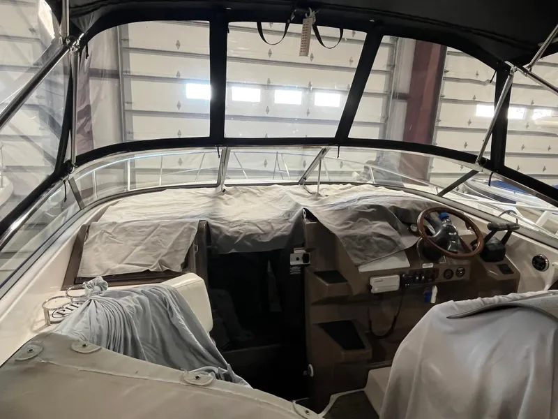 Slide: The Image of 2006 Regal 3360 Window Express boat interior with covered seats and steering wheel. - 16