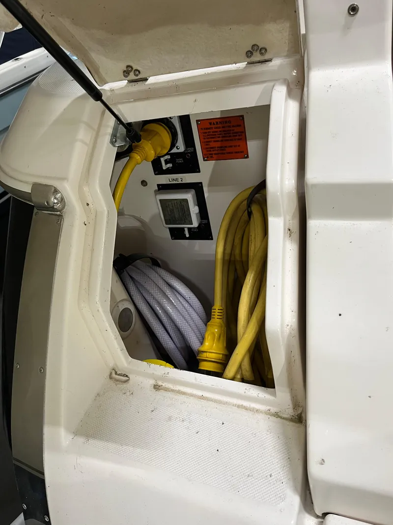 Slide: The Image of Storage compartment of a 2006 Regal 3360 Window Express boat with cables and hoses. - 27