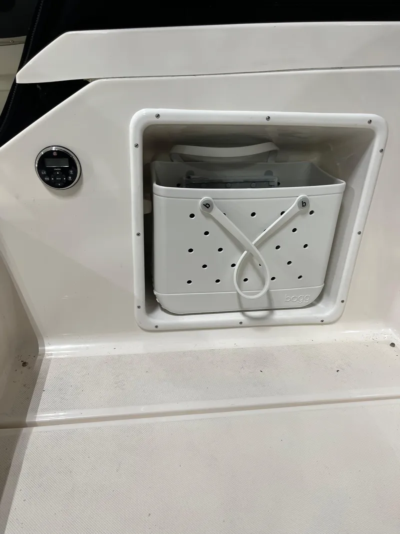 Slide: The Image of 2006 Regal 3360 Window Express boat storage compartment with white container. - 28