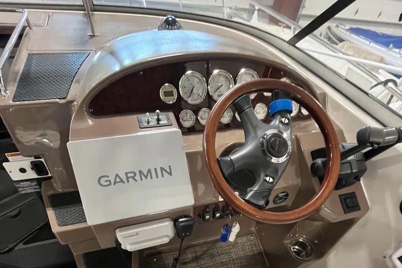 Slide: The Image of 2006 Regal 3360 Window Express dashboard with Garmin navigation and wood-trimmed steering wheel. - 34